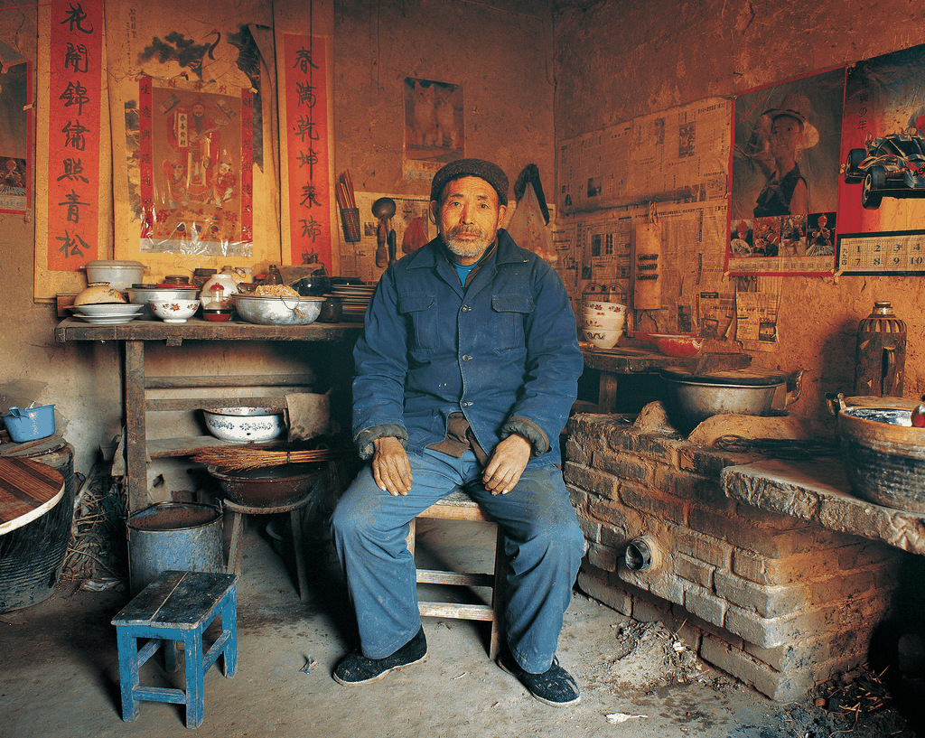 一位端坐在土坯房内的老人