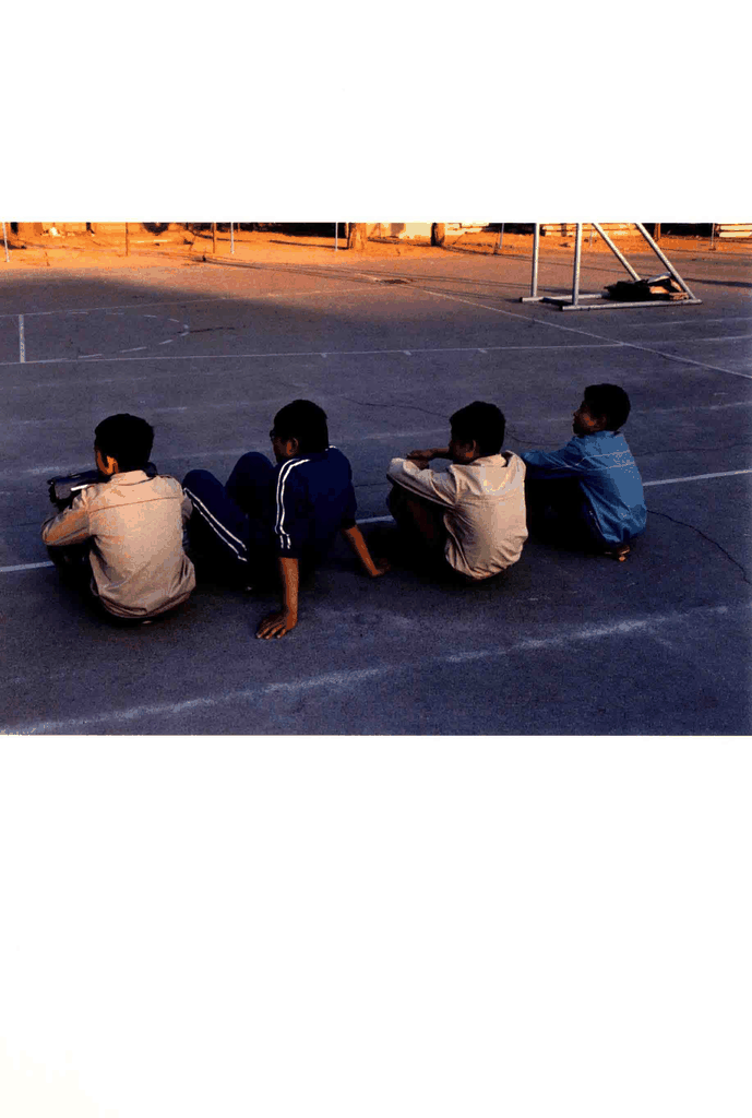 四个少年坐在操场边