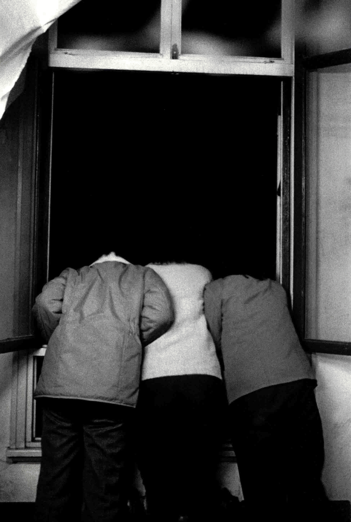 三个孩子趴在窗前向外张望